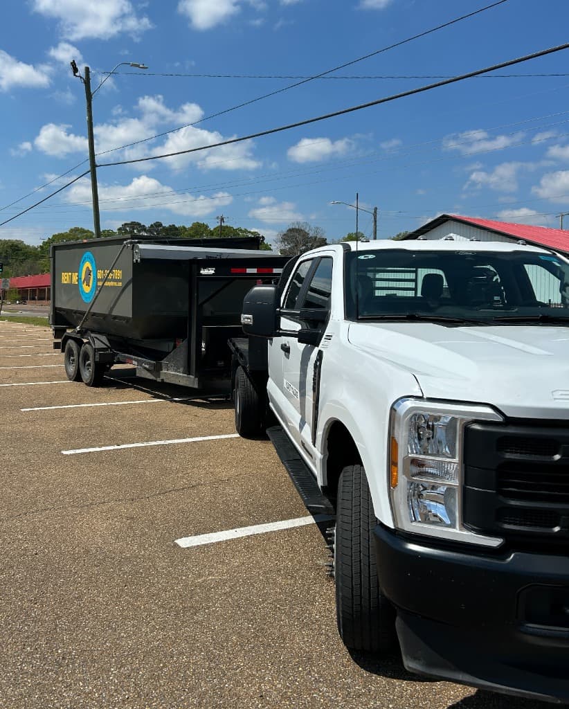 Ford F-350 hauling branded dumpster trailer in Central Mississippi